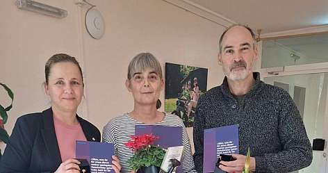 Eine junge Frau und ein älterer Mann malen zusammen im Garten.