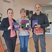 Eine junge Frau und ein älterer Mann malen zusammen im Garten.